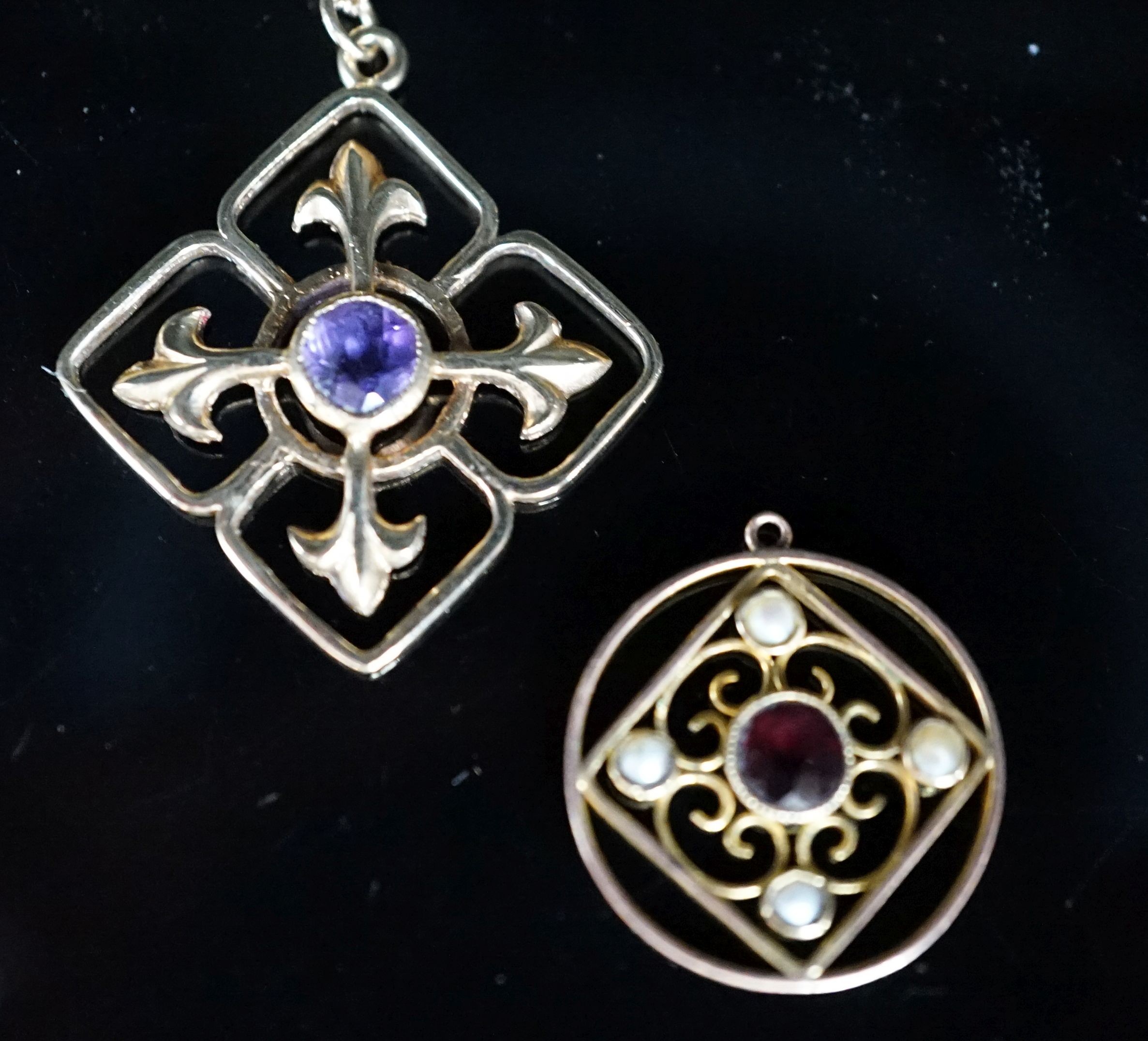 Two yellow metal and gem set pendants, including circular garnet and seed pearl set, 17mm, the largest on a 9ct gold chain, gross weight 6 grams.
